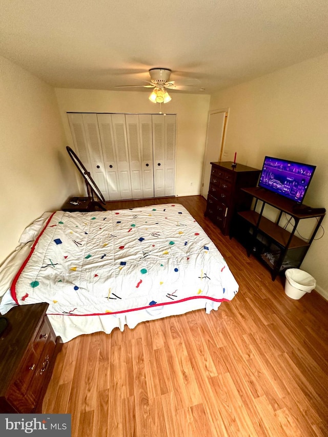 bedroom featuring wood finished floors, a closet, and ceiling fan
