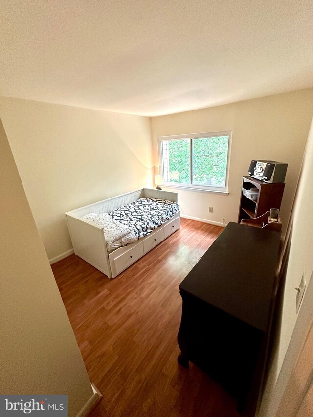 bedroom with wood finished floors and baseboards