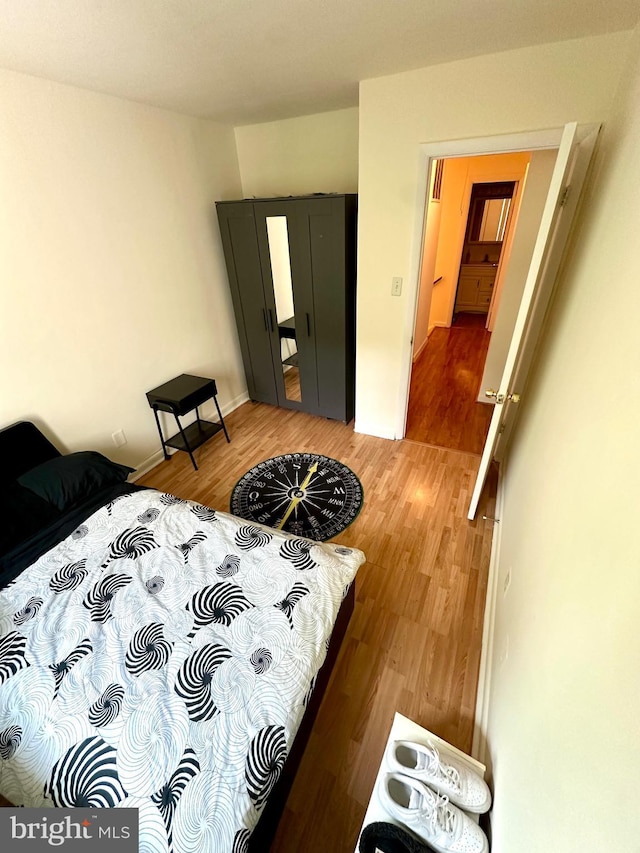 bedroom with wood finished floors and baseboards