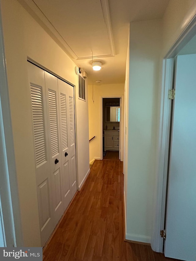 corridor with attic access and dark wood finished floors