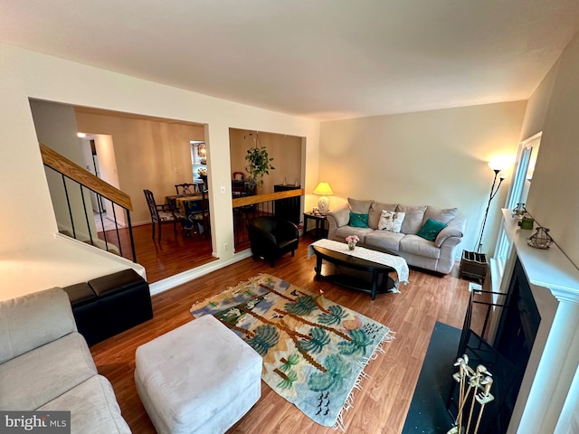 living room featuring wood finished floors and stairway