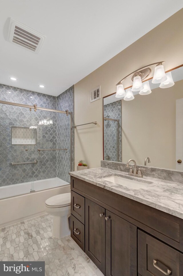 bathroom with shower / bath combination with glass door, visible vents, toilet, and vanity