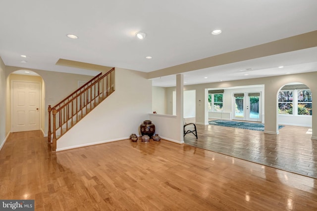 interior space with stairs, a healthy amount of sunlight, wood finished floors, and baseboards