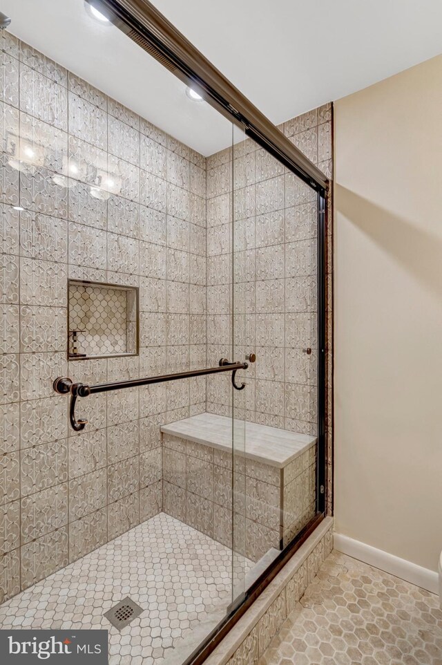 full bath with baseboards and a shower stall