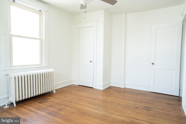 8 Oakley Rd, Upper Darby, PA 19082 - unfurnished bedroom featuring radiator, multiple windows, and light wood-style floors