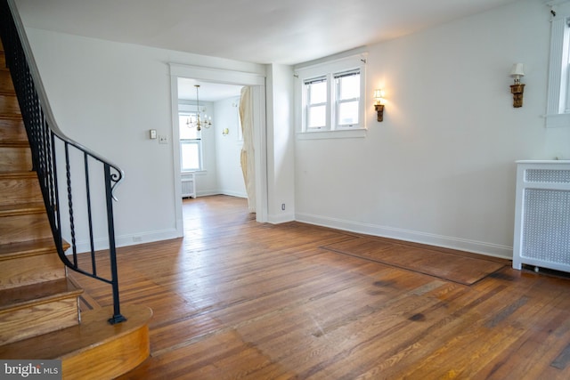8 Oakley Rd, Upper Darby, PA 19082 - unfurnished living room featuring healthy amount of natural light, radiator, stairway, and hardwood / wood-style floors