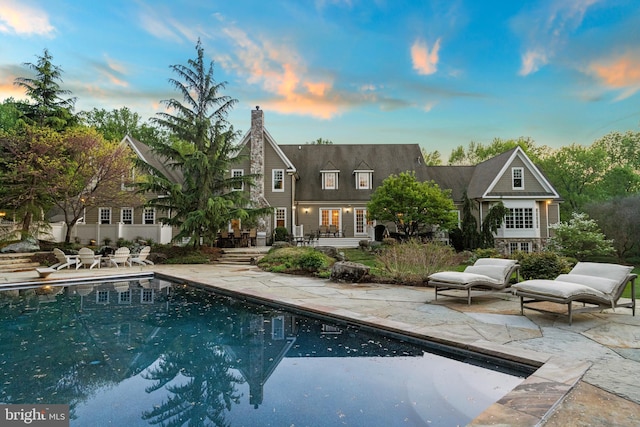 11820 Plantation Dr, Great Falls, VA 22066 - back of house with a patio, an outdoor pool, and a chimney