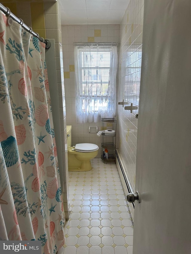 full bathroom featuring toilet, curtained shower, tile walls, and baseboard heating