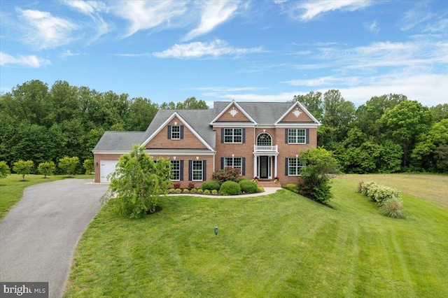 12670 Perrywood Ln, Dunkirk, MD 20754 - colonial inspired home with brick siding, a front yard, asphalt driveway, and an attached garage
