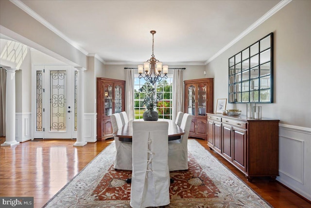12670 Perrywood Ln, Dunkirk, MD 20754 - dining space with a chandelier, wood finished floors, crown molding, decorative columns, and a decorative wall