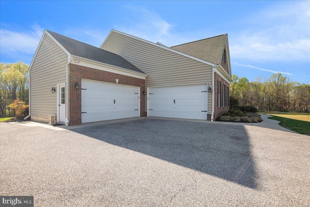 12670 Perrywood Ln, Dunkirk, MD 20754 - view of side of home with a garage, brick siding, driveway, and a shingled roof