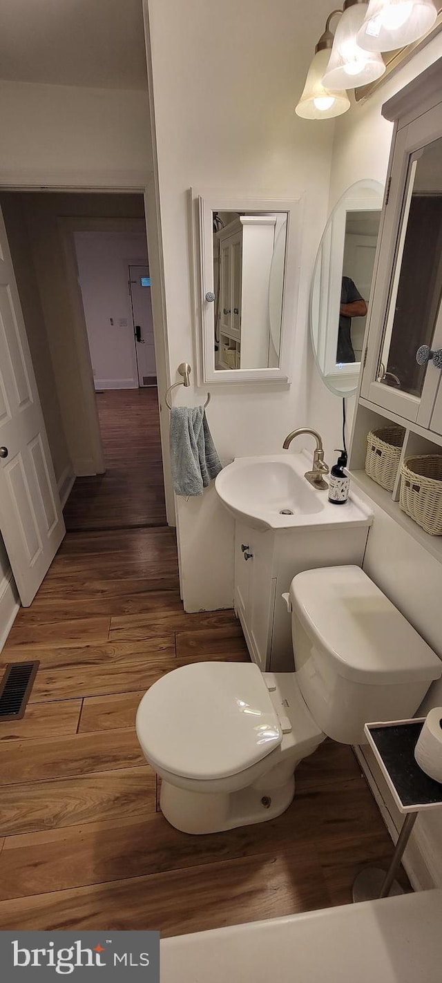2920 Dares Beach Rd, Prince Frederick, MD 20678 - half bath featuring wood finished floors, toilet, and vanity