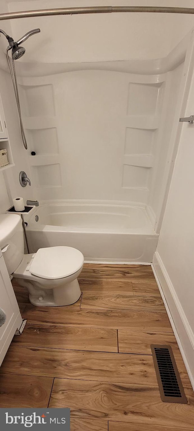 2920 Dares Beach Rd, Prince Frederick, MD 20678 - bathroom featuring toilet, wood finished floors, bathing tub / shower combination, and baseboards