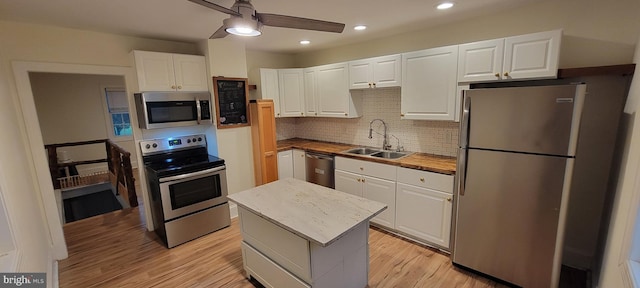 2920 Dares Beach Rd, Prince Frederick, MD 20678 - kitchen featuring appliances with stainless steel finishes, a sink, a ceiling fan, white cabinets, and light wood-type flooring