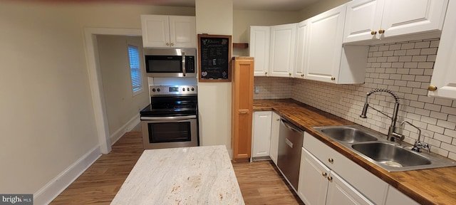 2920 Dares Beach Rd, Prince Frederick, MD 20678 - kitchen featuring appliances with stainless steel finishes, butcher block countertops, a sink, and white cabinetry