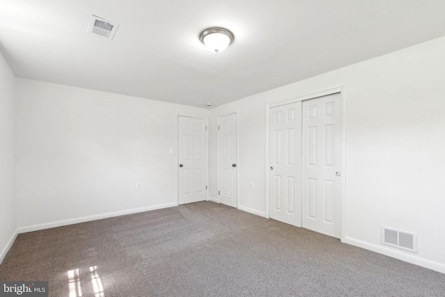 unfurnished bedroom featuring baseboards, visible vents, and carpet flooring