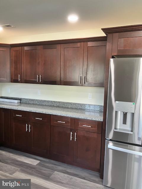111 Heulings Ave, Riverside, NJ 08075 - kitchen featuring stainless steel fridge, light wood-style floors, light stone counters, and dark brown cabinetry