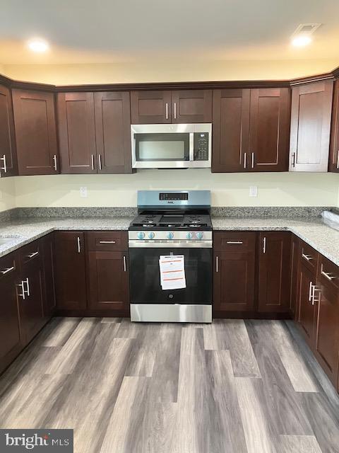 111 Heulings Ave, Riverside, NJ 08075 - kitchen featuring appliances with stainless steel finishes, dark brown cabinetry, light stone counters, and light wood-type flooring