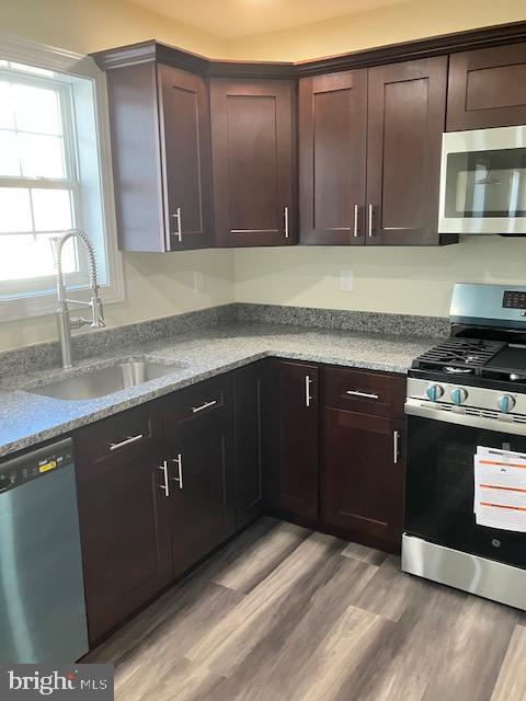 111 Heulings Ave, Riverside, NJ 08075 - kitchen with appliances with stainless steel finishes, a sink, light wood-style flooring, and dark brown cabinetry