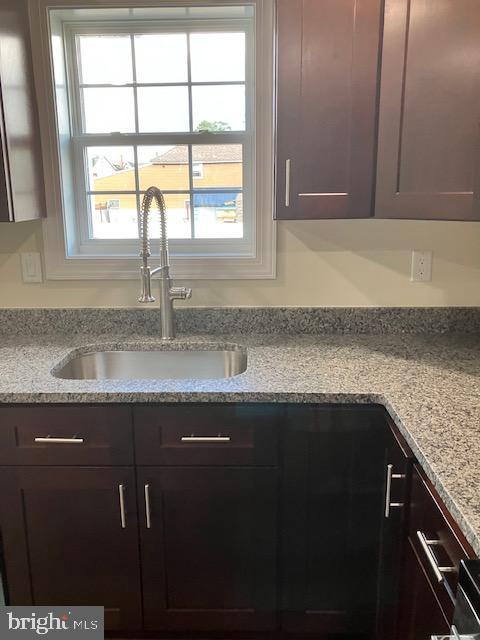 111 Heulings Ave, Riverside, NJ 08075 - kitchen featuring a sink, dark brown cabinetry, and light stone counters