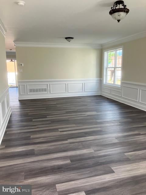 111 Heulings Ave, Riverside, NJ 08075 - empty room with ornamental molding, plenty of natural light, dark wood-type flooring, a wainscoted wall, and a decorative wall