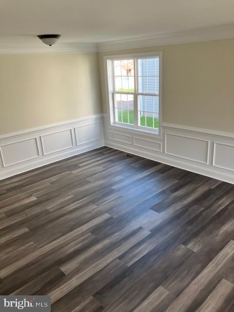 111 Heulings Ave, Riverside, NJ 08075 - empty room featuring crown molding, a wainscoted wall, and dark wood-type flooring