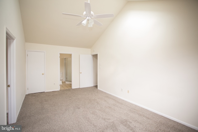 unfurnished bedroom featuring connected bathroom, baseboards, high vaulted ceiling, and carpet floors