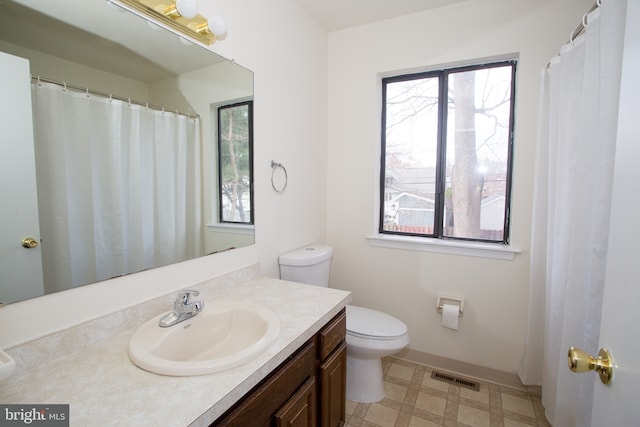 bathroom with tile patterned floors, visible vents, toilet, and a wealth of natural light