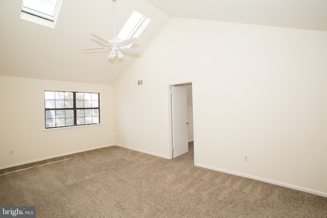 unfurnished room with high vaulted ceiling, a skylight, visible vents, a ceiling fan, and light carpet