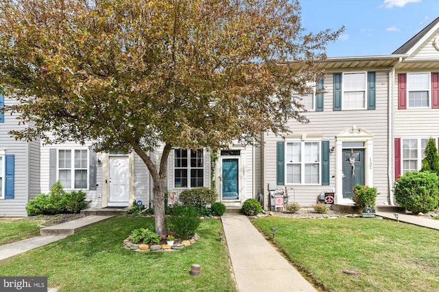 townhome / multi-family property featuring a front lawn