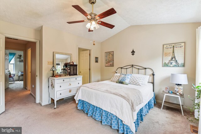 bedroom with light colored carpet, a ceiling fan, vaulted ceiling, and baseboards