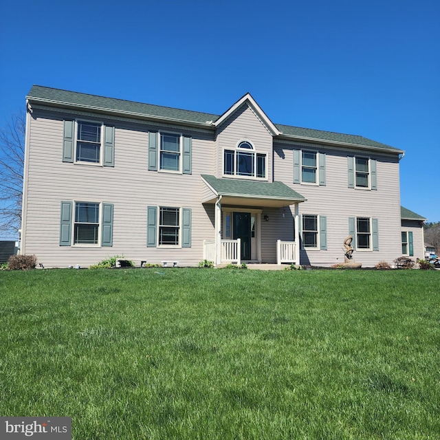 colonial-style house featuring a front lawn