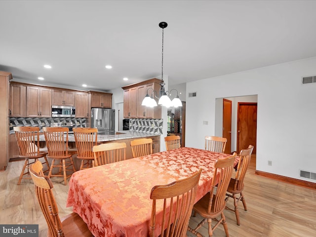 dining space with recessed lighting, light wood finished floors, and visible vents