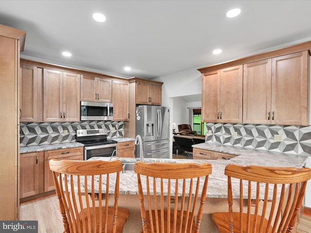 kitchen featuring a peninsula, appliances with stainless steel finishes, decorative backsplash, and recessed lighting