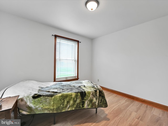 bedroom featuring baseboards and wood finished floors
