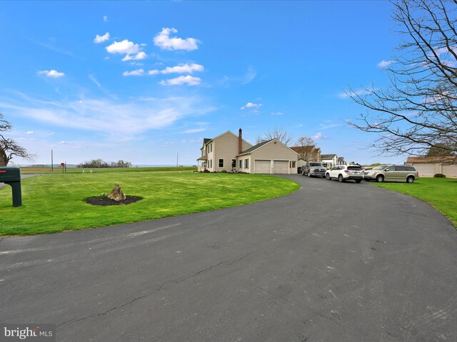 view of front of home with aphalt driveway, a front yard, and an attached garage