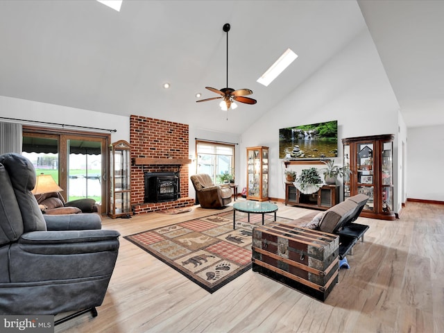 living area with high vaulted ceiling, wood finished floors, a ceiling fan, and a skylight