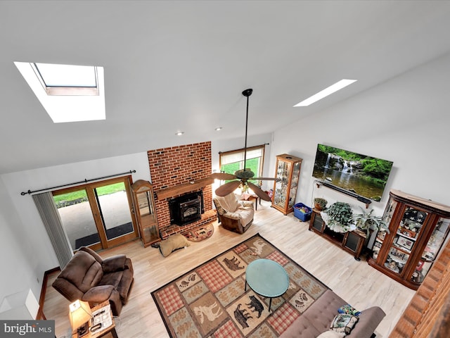 living room with a skylight, wood finished floors, and a fireplace