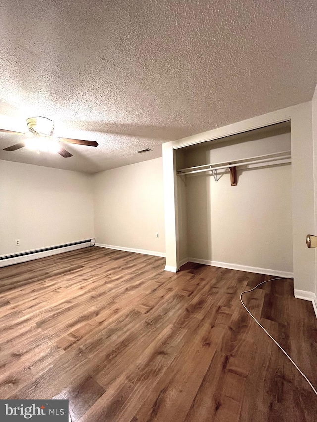 13306 Partridge Dr, Silver Spring, MD 20904 - unfurnished bedroom featuring baseboard heating, wood finished floors, a textured ceiling, a ceiling fan, and baseboards