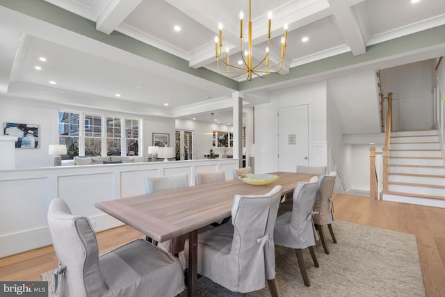 dining room with beamed ceiling, ornamental molding, light wood-type flooring, an inviting chandelier, and coffered ceiling