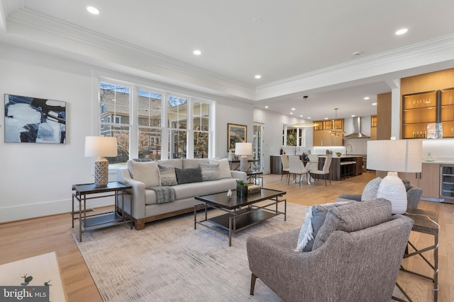 living area featuring light wood finished floors, ornamental molding, and recessed lighting