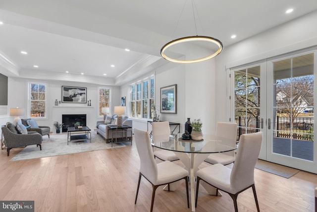 dining room with plenty of natural light, light wood-type flooring, and a raised ceiling