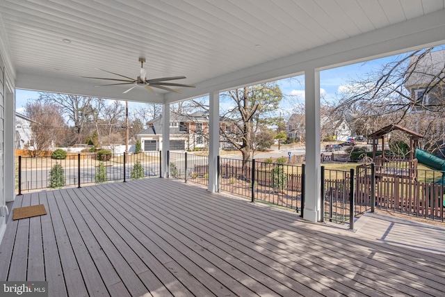 wooden deck featuring a ceiling fan and a playground