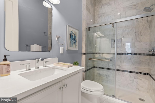 bathroom with toilet, a stall shower, and vanity