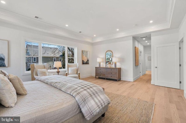 bedroom featuring light wood finished floors, visible vents, crown molding, and a raised ceiling