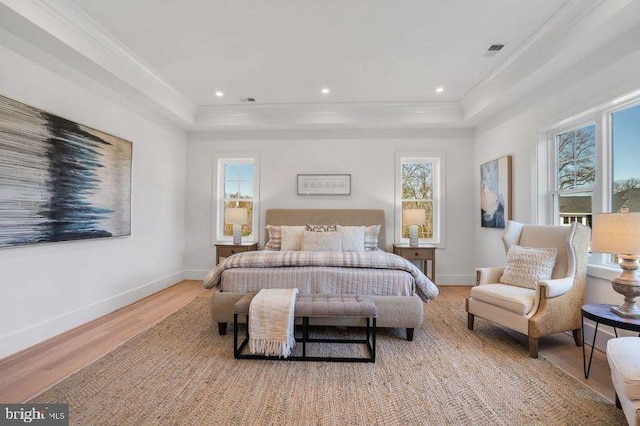 bedroom featuring wood finished floors, crown molding, baseboards, and visible vents