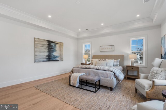 bedroom with a tray ceiling, multiple windows, and crown molding