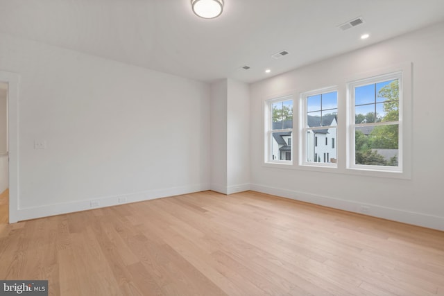 spare room with baseboards, visible vents, light wood-style floors, and recessed lighting