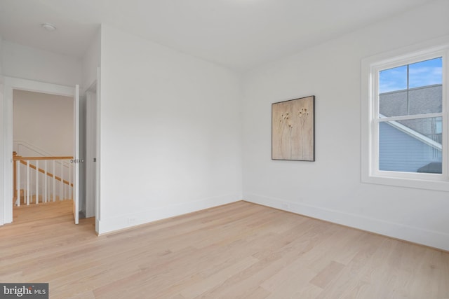 unfurnished room with baseboards and light wood-style flooring