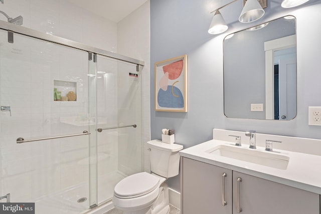bathroom with toilet, vanity, and a shower stall